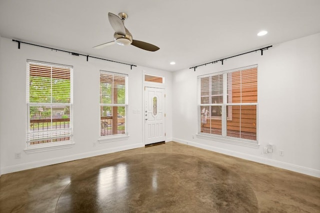 interior space featuring ceiling fan and concrete floors