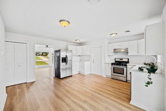 kitchen with sink, white cabinets, stainless steel appliances, and light wood-type flooring