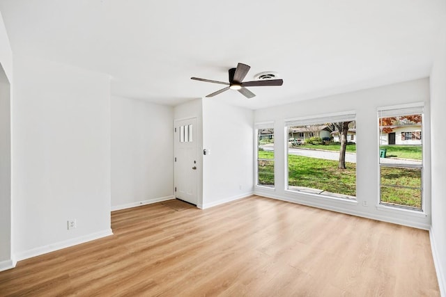 spare room featuring ceiling fan, light wood-type flooring, and a wealth of natural light