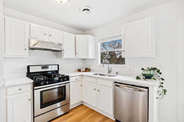 kitchen with sink, stainless steel appliances, light hardwood / wood-style flooring, extractor fan, and white cabinets