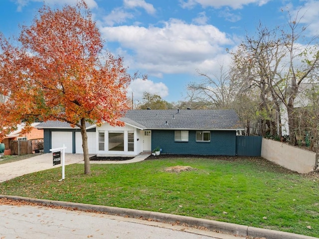 ranch-style home with a garage and a front lawn