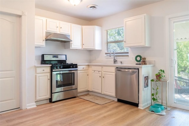 5201 Periwinkle Path, Austin, TX 78745 - kitchen featuring stainless steel appliances, light wood-style floors, under cabinet range hood, and white cabinets