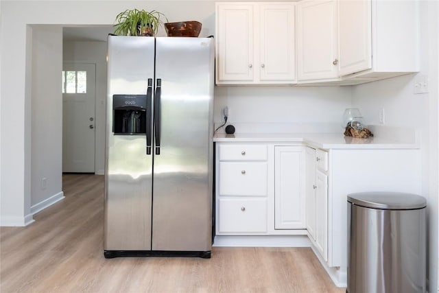 5201 Periwinkle Path, Austin, TX 78745 - kitchen with stainless steel fridge, white cabinets, light wood finished floors, and light countertops