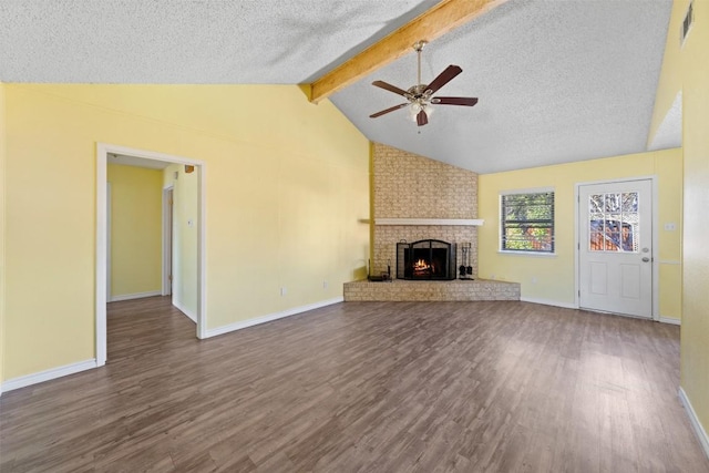 unfurnished living room featuring a fireplace, hardwood / wood-style floors, lofted ceiling with beams, and a textured ceiling