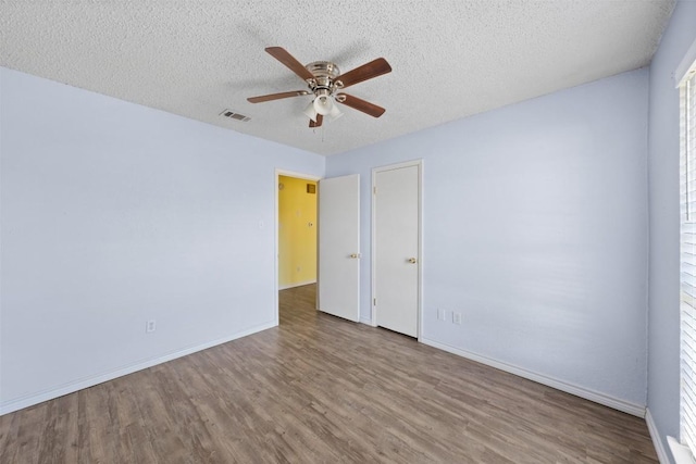 spare room with ceiling fan, wood-type flooring, and a textured ceiling