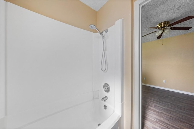 bathroom featuring bathtub / shower combination, hardwood / wood-style floors, a textured ceiling, and ceiling fan