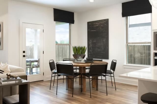 dining room with light hardwood / wood-style floors and a healthy amount of sunlight