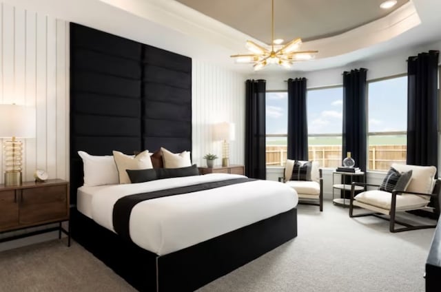 bedroom with carpet flooring, ceiling fan with notable chandelier, and a tray ceiling