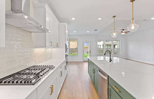 3353 Vestland Fjord St, Leander, TX 78641 - kitchen with a sink, white cabinets, green cabinetry, stainless steel appliances, and wall chimney exhaust hood