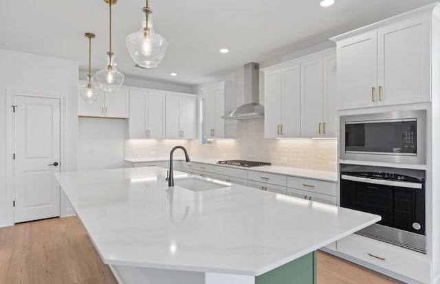 3353 Vestland Fjord St, Leander, TX 78641 - kitchen featuring a kitchen island with sink, backsplash, a sink, stainless steel appliances, and wall chimney exhaust hood