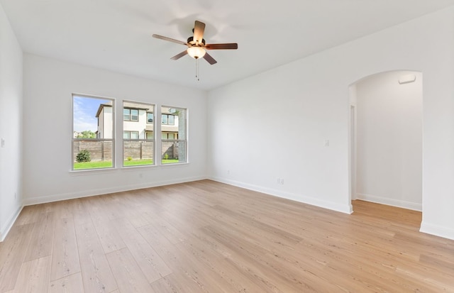 3353 Vestland Fjord St, Leander, TX 78641 - empty room featuring arched walkways, ceiling fan, baseboards, and light wood-type flooring