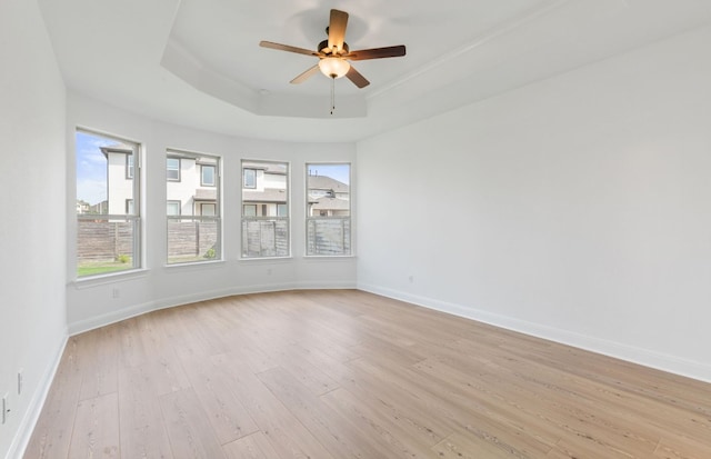 3353 Vestland Fjord St, Leander, TX 78641 - spare room featuring a tray ceiling, baseboards, a ceiling fan, and light wood-type flooring