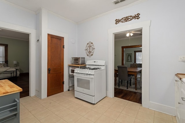 kitchen featuring ceiling fan, ornamental molding, and white gas range oven