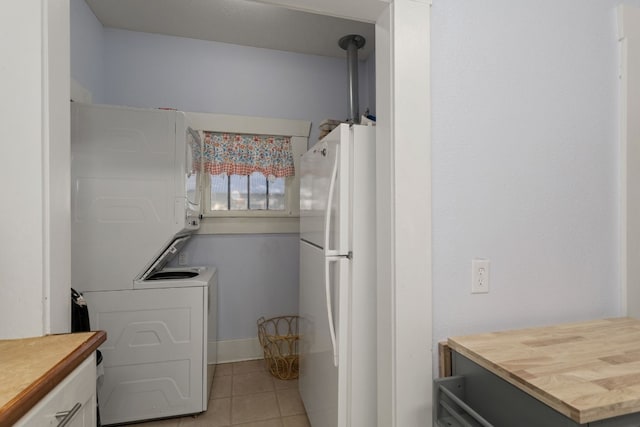 washroom featuring light tile patterned floors and stacked washer / dryer