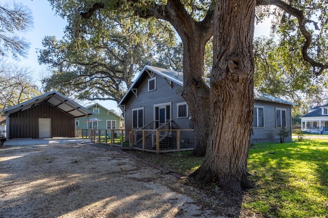 back of house with a yard, an outbuilding, and a garage