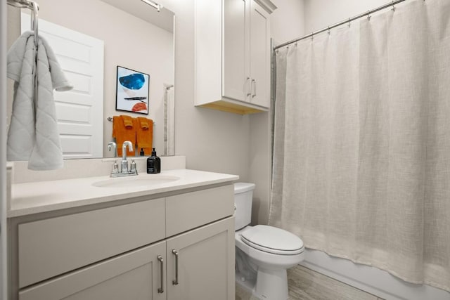 full bathroom with shower / tub combo with curtain, vanity, wood-type flooring, and toilet