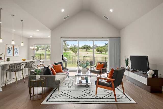 living room with a chandelier, hardwood / wood-style floors, and a wealth of natural light