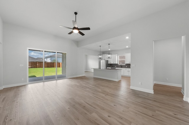 unfurnished living room with ceiling fan and light hardwood / wood-style floors