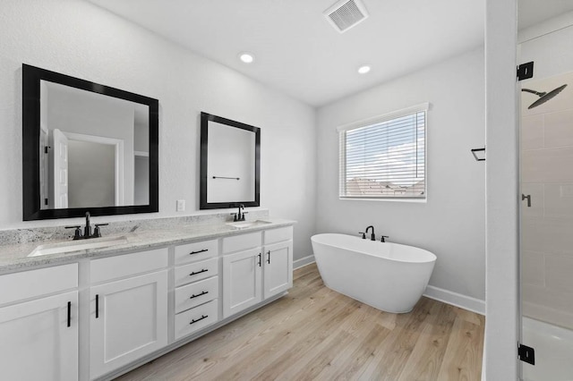 bathroom featuring hardwood / wood-style floors, vanity, and independent shower and bath