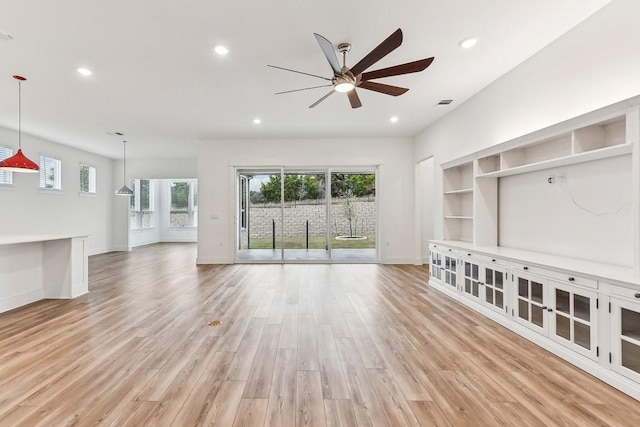 unfurnished living room featuring ceiling fan and light hardwood / wood-style floors