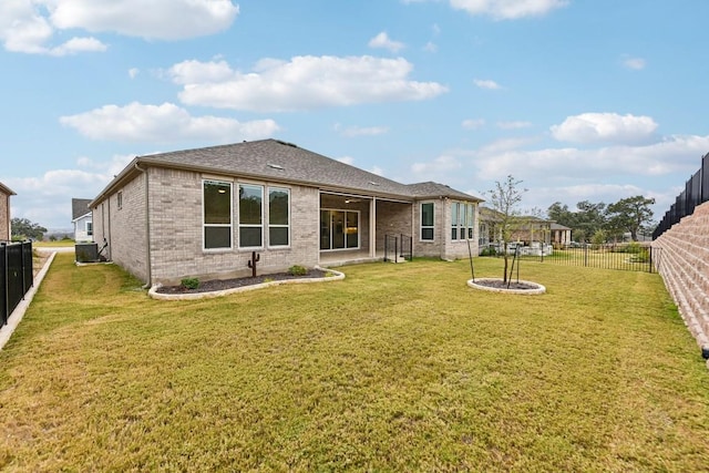 back of property featuring a yard and central AC unit