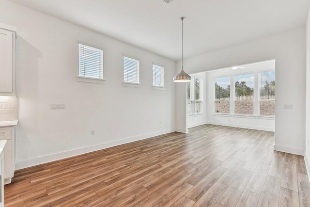 unfurnished dining area with light hardwood / wood-style floors and plenty of natural light