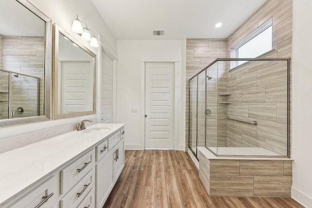 bathroom with hardwood / wood-style floors, vanity, and walk in shower