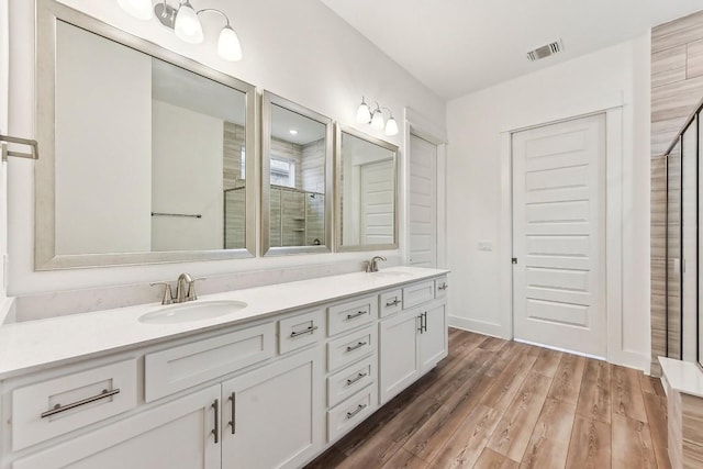 bathroom featuring vanity, a shower with shower door, and hardwood / wood-style flooring