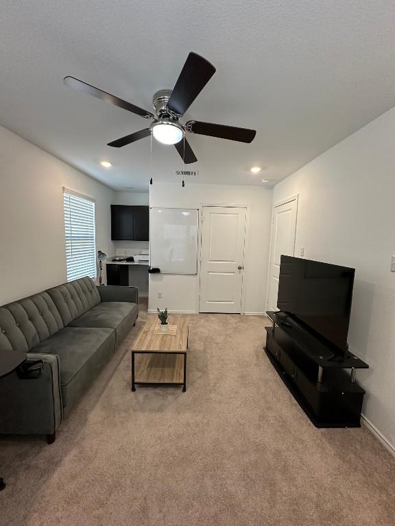 living room featuring carpet floors and ceiling fan