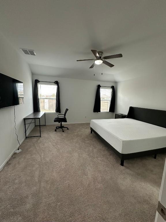 unfurnished bedroom with carpet flooring, multiple windows, and ceiling fan