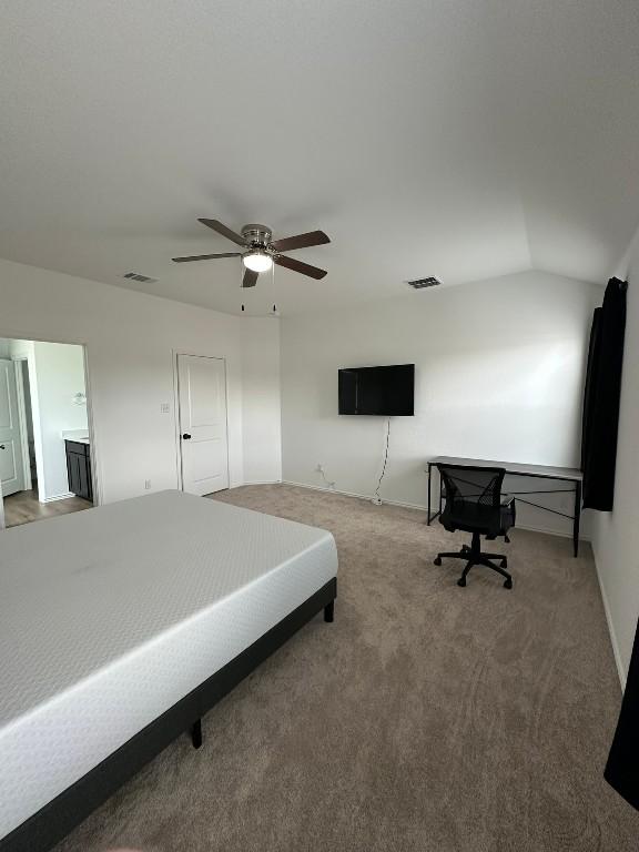 bedroom with carpet, connected bathroom, ceiling fan, and lofted ceiling