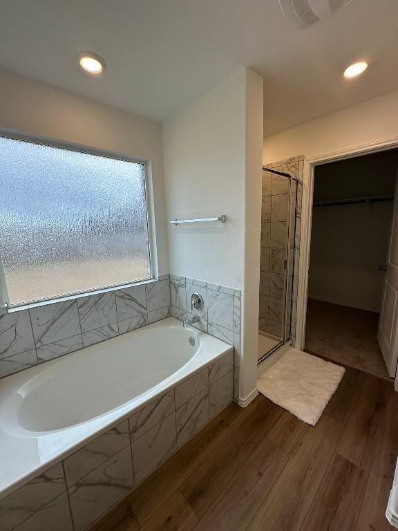 bathroom featuring hardwood / wood-style flooring and independent shower and bath