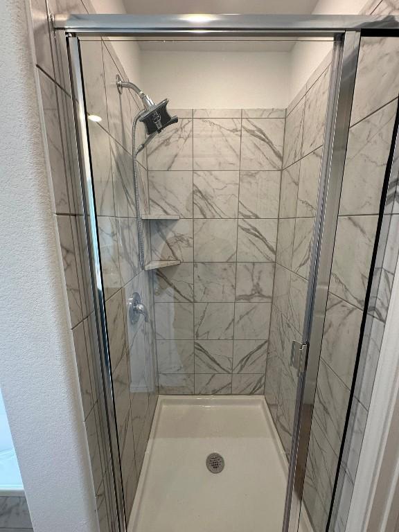 bathroom featuring a shower with door