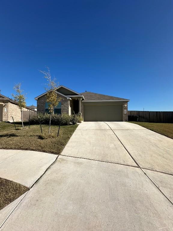 ranch-style house featuring a front yard and a garage