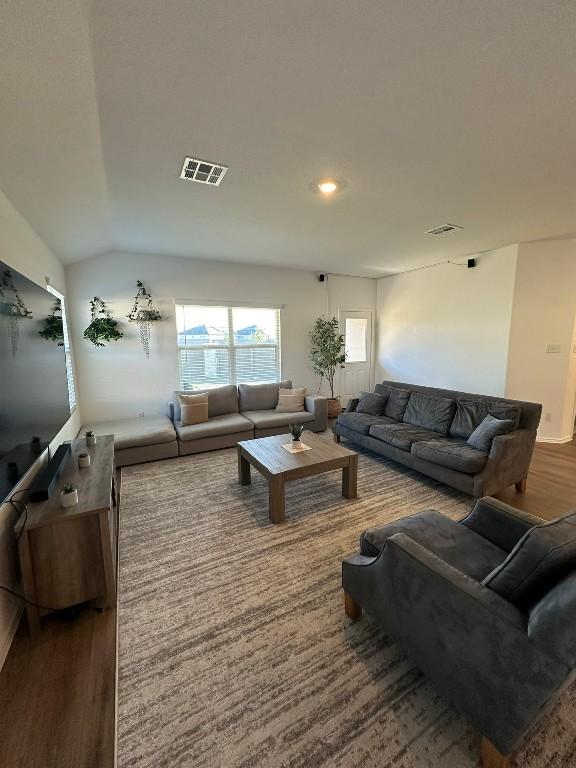 living room with dark wood-type flooring and vaulted ceiling