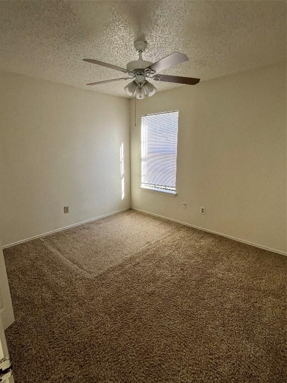 carpeted empty room with a textured ceiling and ceiling fan