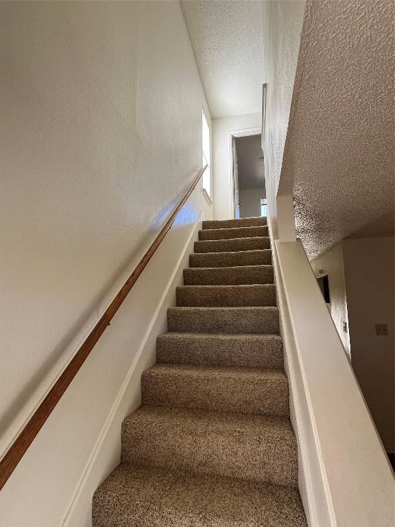 stairway with a textured ceiling