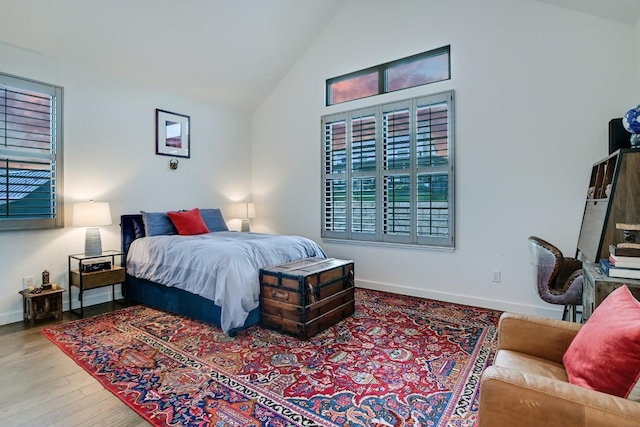 bedroom featuring wood-type flooring and high vaulted ceiling