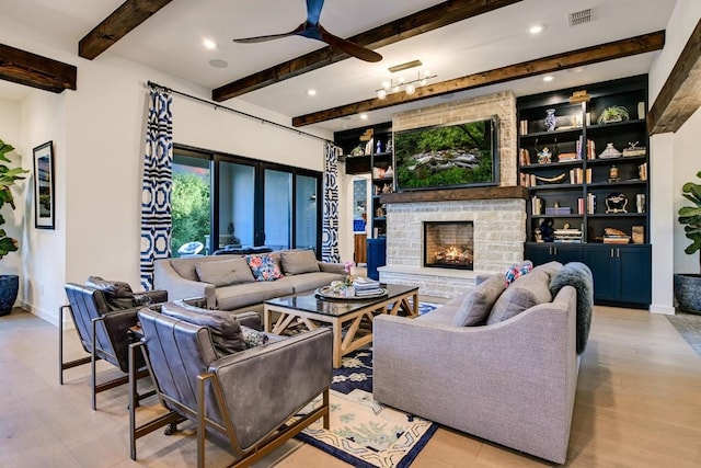 living room featuring ceiling fan, beam ceiling, light hardwood / wood-style floors, and a fireplace