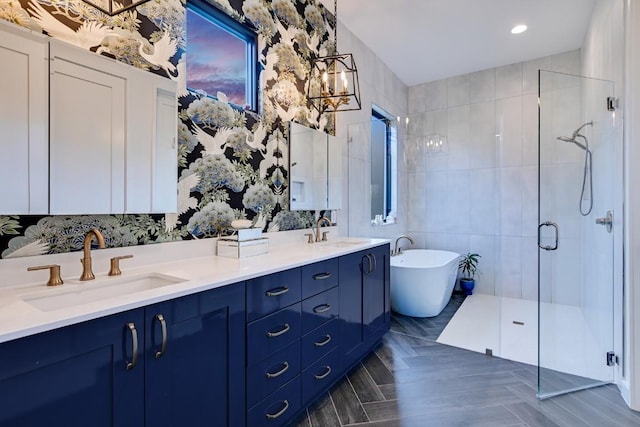 bathroom featuring plus walk in shower, vanity, and tile walls