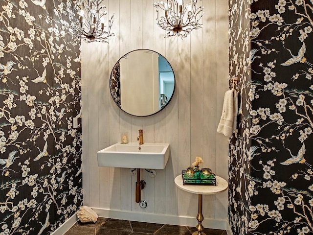 bathroom with wood walls, sink, tile patterned flooring, and a notable chandelier