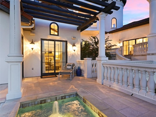 patio terrace at dusk featuring a pergola