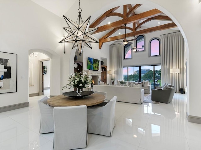 dining room featuring ceiling fan with notable chandelier, beam ceiling, light tile patterned floors, and high vaulted ceiling