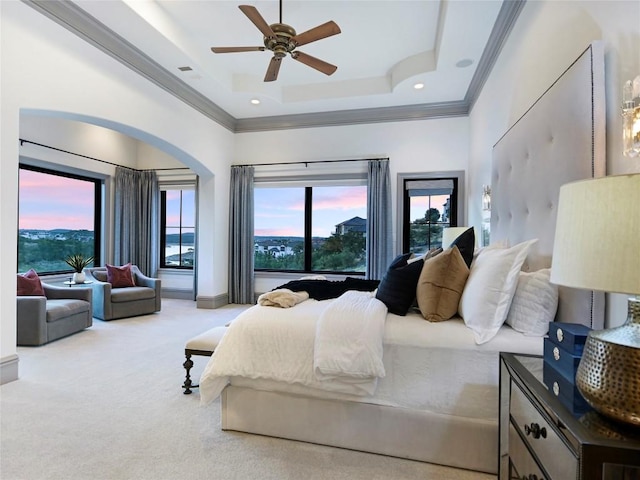 carpeted bedroom featuring a tray ceiling, ceiling fan, and ornamental molding