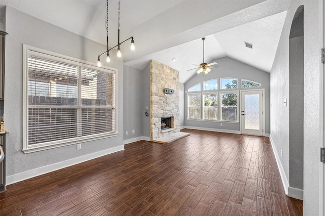 unfurnished living room featuring a stone fireplace, ceiling fan, and lofted ceiling