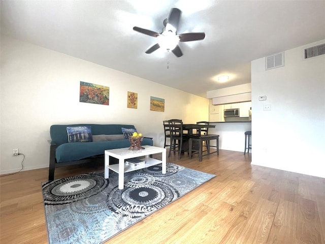 living room with ceiling fan and light wood-type flooring