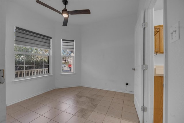 unfurnished room with ceiling fan and light tile patterned floors