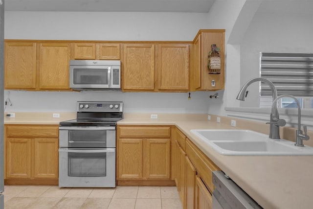 kitchen featuring light tile patterned flooring, stainless steel appliances, and sink