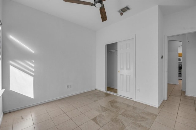 unfurnished bedroom featuring ceiling fan, light tile patterned floors, and a closet