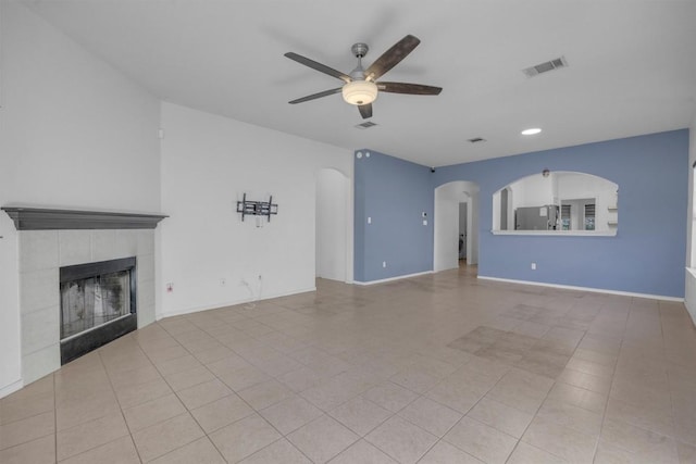 unfurnished living room with ceiling fan, light tile patterned flooring, and a fireplace